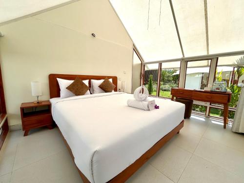 a bedroom with a large bed with a towel on it at Svargan Lakeside Glamping in Tabanan