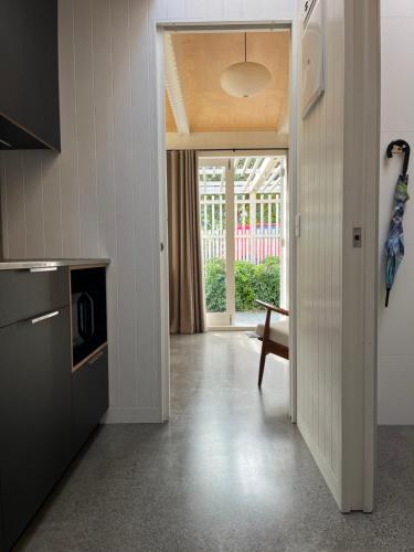 a kitchen with a door leading to a dining room at Stylish Eden Park Studio in Auckland