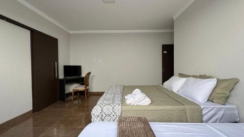 En eller flere senge i et værelse på DiLUCCA Suíte 03 - Pousada Karaiba Próx UMC, Praia Clube e Shopping