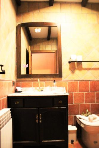 a bathroom with a sink and a mirror and a toilet at Hotel Rural Vistahermosa in Béjar