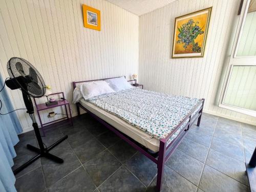 - une petite chambre avec un lit et un ventilateur dans l'établissement Appartement T2 avec terrasse, parking privé, à 600m de la plage - Idéal famille et animaux admis - FR-1-309-477, à Saint-Cyprien