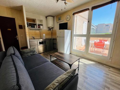 un salon avec un canapé et une table dans l'établissement Appartement T2 avec terrasse, parking privé, à 600m de la plage - Idéal famille et animaux admis - FR-1-309-477, à Saint-Cyprien