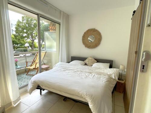 une chambre avec un lit et une grande fenêtre dans l'établissement Appartement à Arcachon : Plage à 50m, Terrasse, Parking, WIFI, 4 Pers - FR-1-474-266, à Arcachon