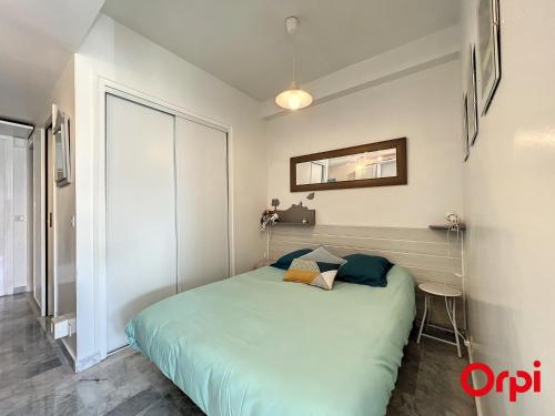 - une chambre avec un grand lit vert dans l'établissement Appartement tranquille avec piscine et WiFi à Menton - FR-1-647-37, à Menton