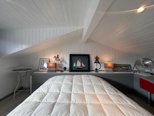 une chambre avec un grand lit blanc dans un grenier dans l'établissement Cœur de Saint-Jean-de-Luz : Appartement lumineux avec balcon, proche plage et commerces - FR-1-239-1079, à Saint-Jean-de-Luz