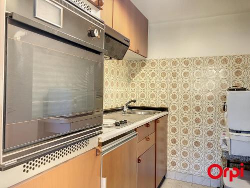 une cuisine avec un évier et une cuisinière four supérieur dans l'établissement Studio avec terrasse, piscine et parking à Menton - FR-1-647-36, à Menton