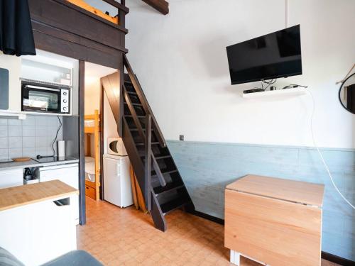 - un salon avec un escalier et une télévision murale dans l'établissement Pavillon Climatisé avec Mezzanine, Piscine et Parking Privé à St Pierre la Mer - FR-1-409A-32, à Fleury