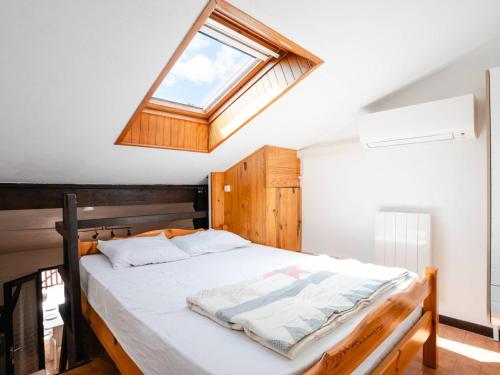 une chambre avec un grand lit avec une lucarne dans l'établissement Pavillon Climatisé avec Mezzanine, Piscine et Parking Privé à St Pierre la Mer - FR-1-409A-32, à Fleury