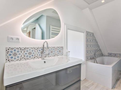 une salle de bain avec un lavabo, une baignoire et un miroir dans l'établissement Maison de Charme à Merville-Franceville-Plage, 10 Pers, Proche Mer, Grande Terrasse et Studio Indépendant - FR-1-788-27, à Merville-Franceville-Plage