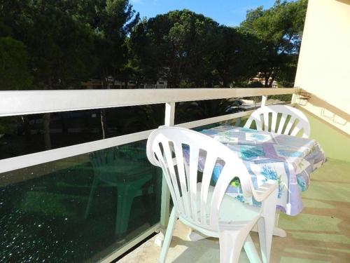 deux chaises et une table sur un balcon dans l'établissement Charmant 3 pièces avec terrasse proche plage et commerces - Bormes-les-Mimosas, 5 couchages, garage inclus - FR-1-251-842, à Bormes-les-Mimosas