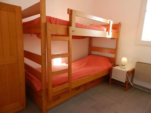une chambre avec deux lits superposés dans une pièce dans l'établissement Charmant 3 pièces avec terrasse proche plage et commerces - Bormes-les-Mimosas, 5 couchages, garage inclus - FR-1-251-842, à Bormes-les-Mimosas