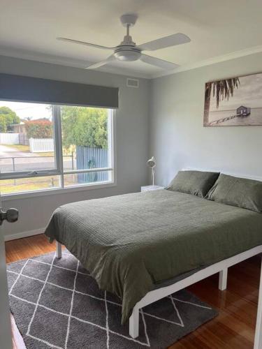 a bedroom with a bed and a ceiling fan at Cowes Cosy Cottage in Phillip Island