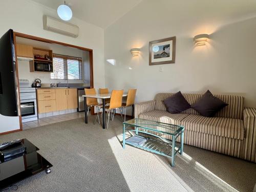 a living room with a couch and a table at Teal Motor Lodge in Gisborne