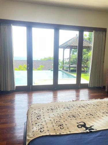 a bedroom with a bed and a view of a pool at Villa Ponjok Batu Residence in Bukti