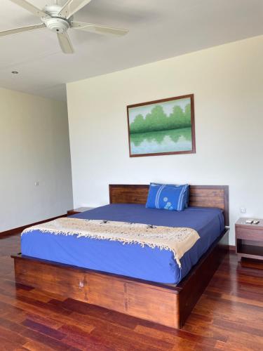 a bed in a bedroom with a ceiling fan at Villa Ponjok Batu Residence in Bukti