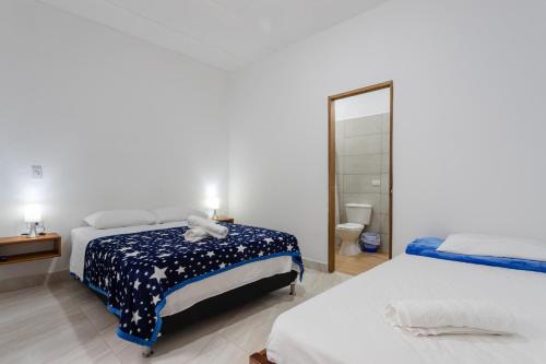 Un dormitorio con dos camas y un espejo. en Apartahotel La Gruta, en Jericó