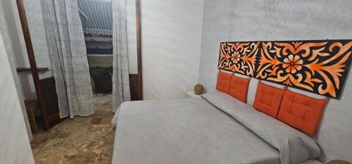 a bedroom with a bed with an orange head board at casa al mare kalispera in Marina di Mancaversa
