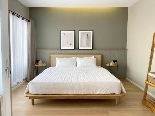 a bed in a bedroom with two pictures on the wall at Vélin Khaosan - 4th Floor apartment with 2Bedrooms in Bangkok