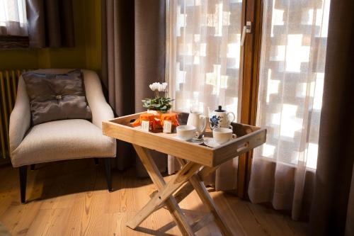 a small wooden table with a chair next to a window at La Burla in Borgosesia