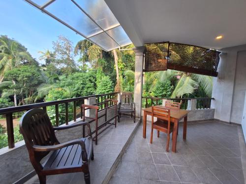a balcony with chairs and a table on a balcony at Villa Goodwill Paradise in Hikkaduwa