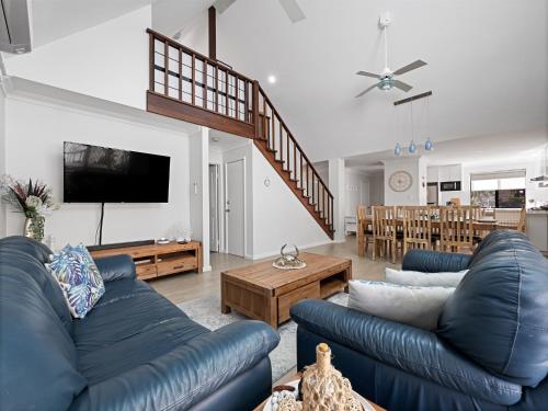 a living room with two blue couches and a tv at Clearwater Escape Dunsborough in Dunsborough