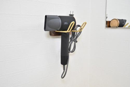 a wall mounted flashlight hanging on a wall at ｹﾞｽﾄﾊｳｽ ﾊﾞｲｸﾔﾉﾆｶｲ in Hagi
