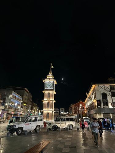 a clock tower in the middle of a city at night at Movie land group of house boats in Srinagar