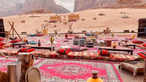 a group of tables in a desert with mountains in the background at Rum rose luxury camp in Wadi Rum