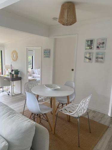 ein Wohnzimmer mit Tisch und Stühlen in der Unterkunft Bee Cottage in Gold Coast