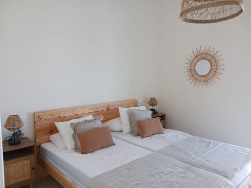 a bedroom with a bed with white sheets and pillows at El Rompido - Punta Coral in El Rompido