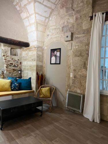 un salon avec un canapé et un mur en pierre dans l'établissement Centre historique quartier piéton, à Montpellier