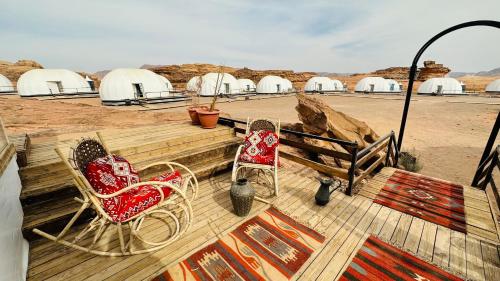 two chairs sitting on a deck in the desert at Rum rose luxury camp in Wadi Rum