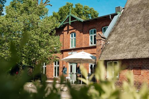 a brick building with an umbrella in front of it at Landgasthof-Unter den Linden in Oelixdorf