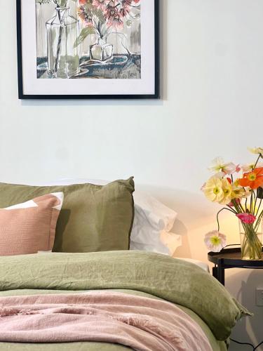 a bedroom with a bed with a vase of flowers at The Baker's Bed - Private 2 King BR Guest Suite in Orange