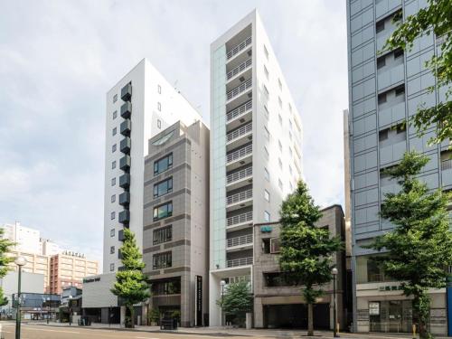 two tall buildings in a city at Hotel Vista Sapporo Odori in Sapporo