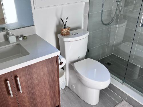 a bathroom with a toilet and a glass shower at Brand New Modern Laneway House in Vancouver