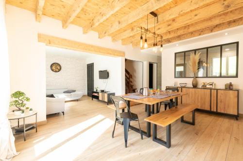une salle à manger et un salon avec une table et des chaises dans l'établissement Le chalet Nicolas, à Lau-Balagnas