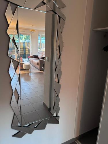 - un miroir suspendu au mur dans le salon dans l'établissement Appartement Résidence du Lac Léman Terasse-Wifi-Netflix-Parking, à Publier
