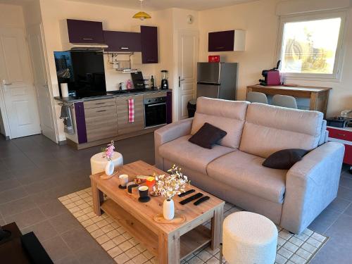 un salon avec un canapé et une table dans l'établissement Appartement Résidence du Lac Léman Terasse-Wifi-Netflix-Parking, à Publier