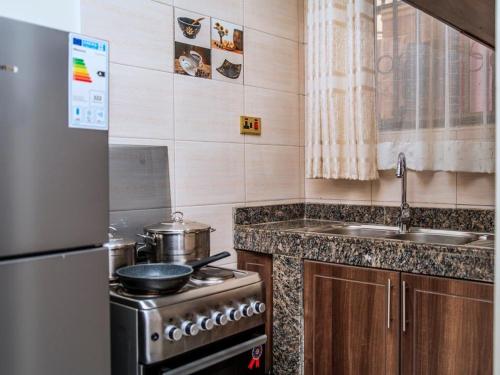 a small kitchen with a stove and a sink at Jengel Studio Apartments Entebbe 1 in Entebbe