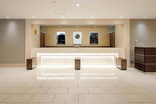 a lobby with a waiting room with a table and posters at Hotel Metropolitan Takasaki in Takasaki