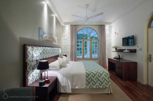 a bedroom with a large bed and a window at Kuwera Kandy in Kandy