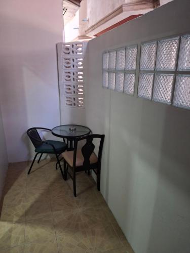 a table and chairs in a room with a window at Traveller's Rest Sports Bar in Pattaya Central