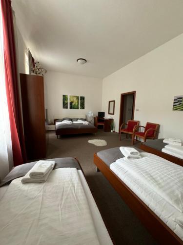 a bedroom with two beds and a living room at Pivovarsky Hotel Kojetín u Kroměříže in Kojetín