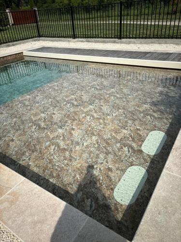 a swimming pool with a shadow of a fence at Le Mas d'Archas Montélimar Sud in Allan