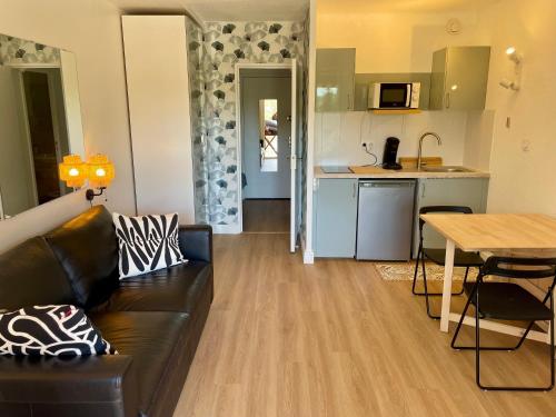 un salon avec un canapé et une table et une cuisine dans l'établissement Studio Saint Cyr sur mer, à Saint-Cyr-sur-Mer