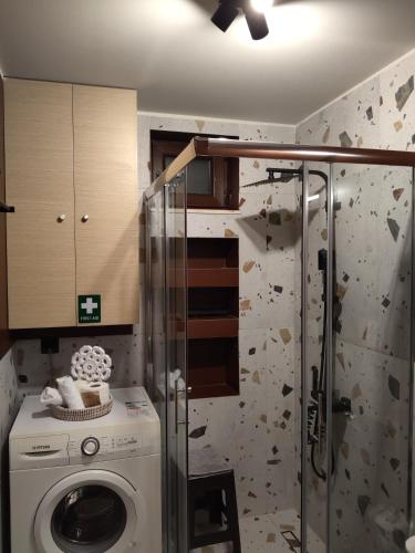a bathroom with a washing machine and a shower at Pasiphae Luxury House in Ierapetra