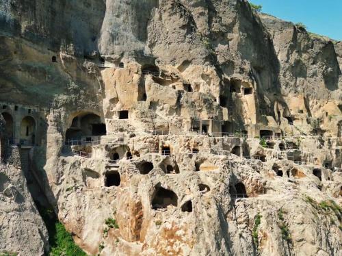 a mountain cliff with many dwellings in it at Akhaltsikhe Inn in Akhaltsikhe