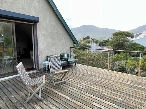 a wooden deck with chairs and a table and a table at Love Nest in Pringle Bay