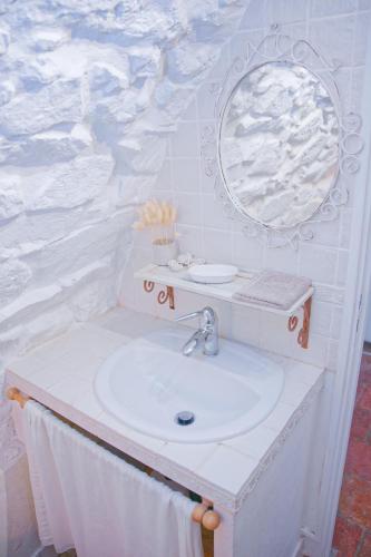 une salle de bain avec un lavabo et un miroir dans l'établissement La Vieille Bergerie, à Èze
